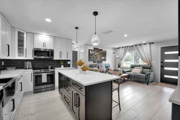 a kitchen with a stove a refrigerator and a dining table with wooden floor