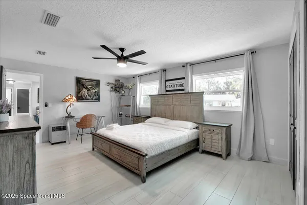 a bedroom with a large bed and a chandelier