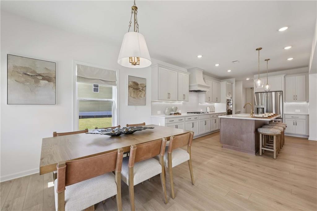 6145 Kismet Road Buford, GA 30518 - Photo 11 of 43 a kitchen with kitchen island a dining table and chairs