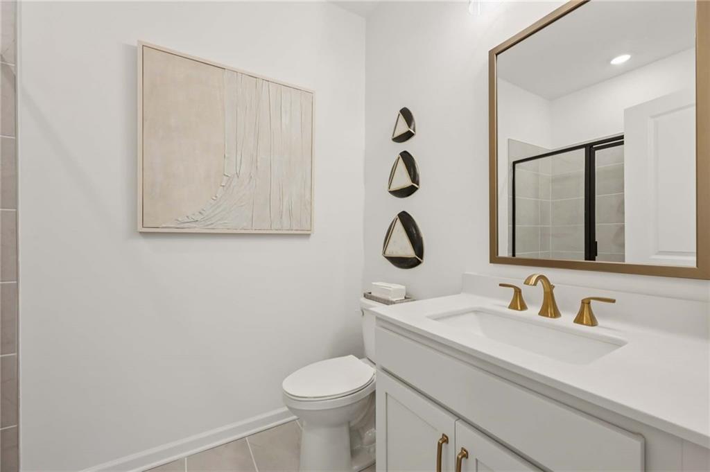 6145 Kismet Road Buford, GA 30518 - Photo 21 of 43 a bathroom with a sink a toilet and a mirror