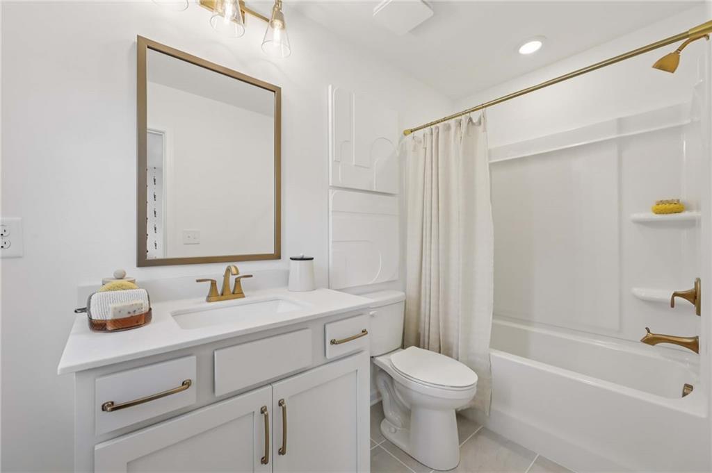 6145 Kismet Road Buford, GA 30518 - Photo 32 of 43 a bathroom with a sink a toilet and shower