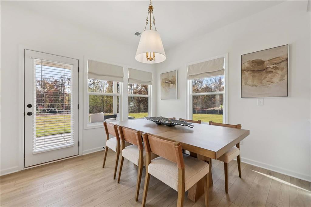 6145 Kismet Road Buford, GA 30518 - Photo 10 of 43 a view of a dining room with furniture window and wooden floor