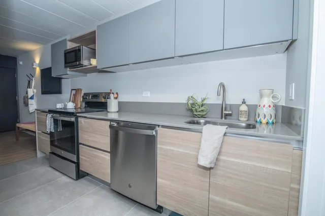 a kitchen with stainless steel appliances white cabinets and wooden floor