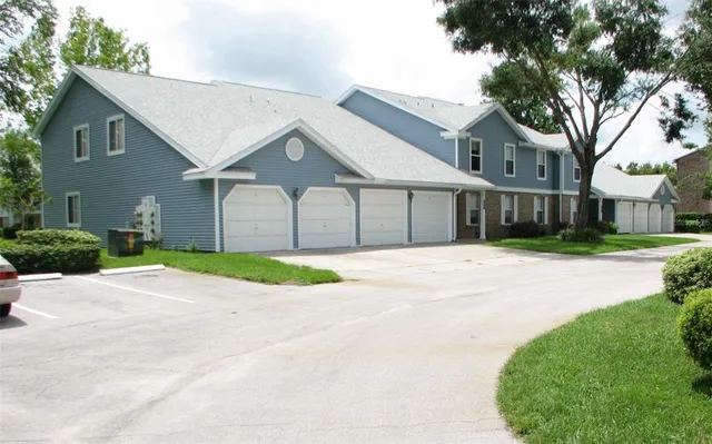 a front view of a house with a garden and trees