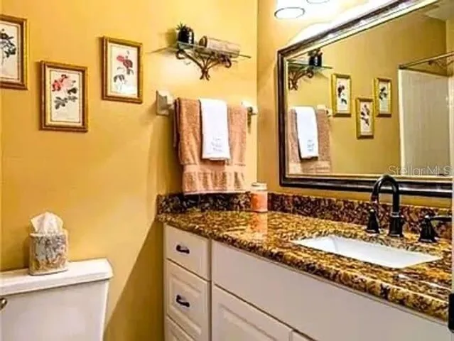 a bathroom with a granite countertop sink and a mirror