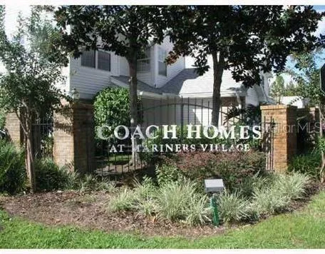 a sign that is sitting in front of a tree