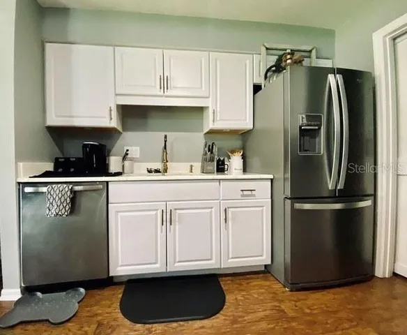 a kitchen with stainless steel appliances granite countertop a refrigerator sink and cabinets