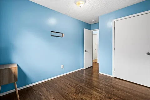 an empty room with wooden floor and closet