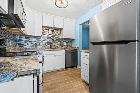 a kitchen with a refrigerator sink and stove