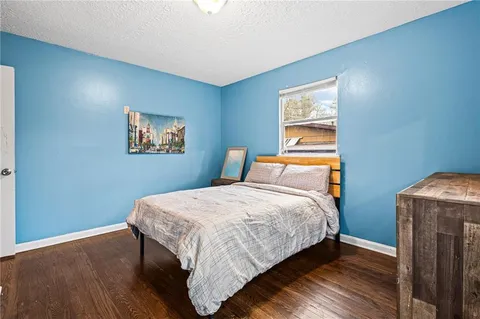a bedroom with bed and wooden floor