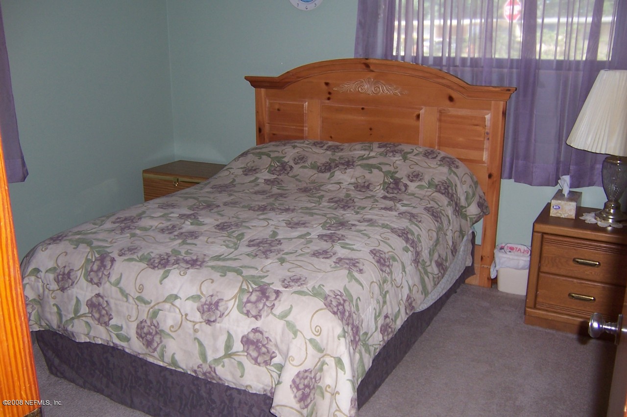 4637 Spring Park Road Jacksonville, FL 32207 - Photo 5 of 10 a bedroom with a bed and dresser