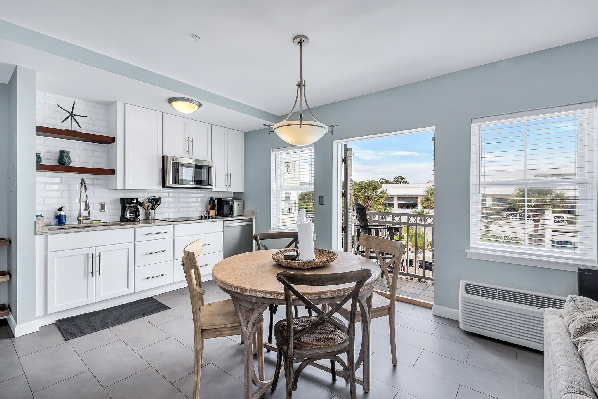 a kitchen with microwave a dining table and chairs