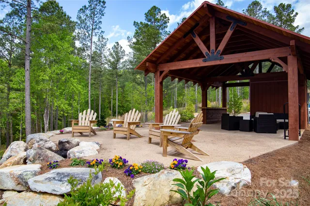 a view of a patio with table and chairs potted plants with wooden floor and roof