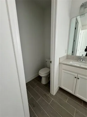 a bathroom with a granite countertop sink toilet and a mirror