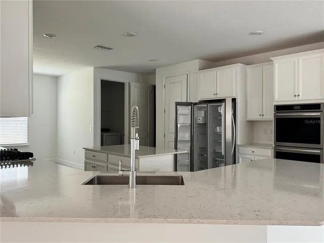 a kitchen with stainless steel appliances kitchen island sink refrigerator and stove