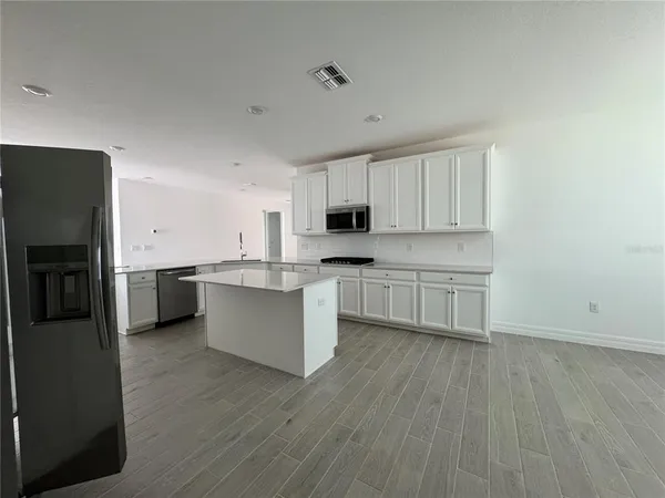 a kitchen with a refrigerator a sink and cabinets