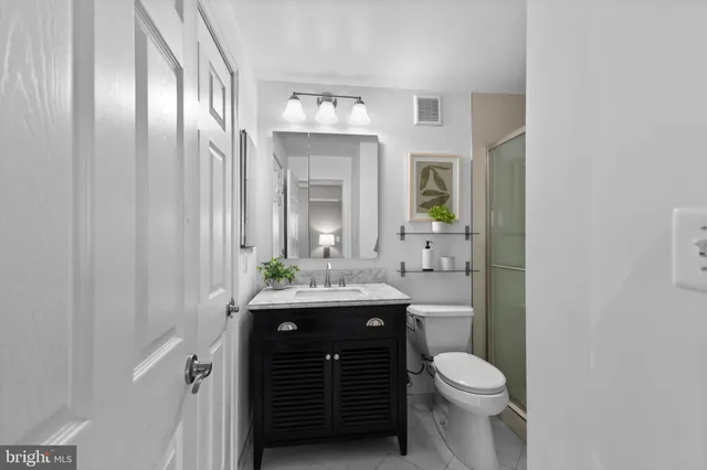 a bathroom with a granite countertop sink a toilet and a mirror