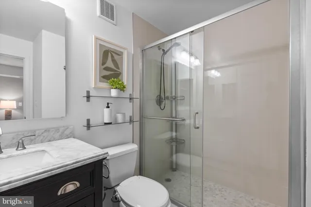 a bathroom with a granite countertop toilet sink and shower