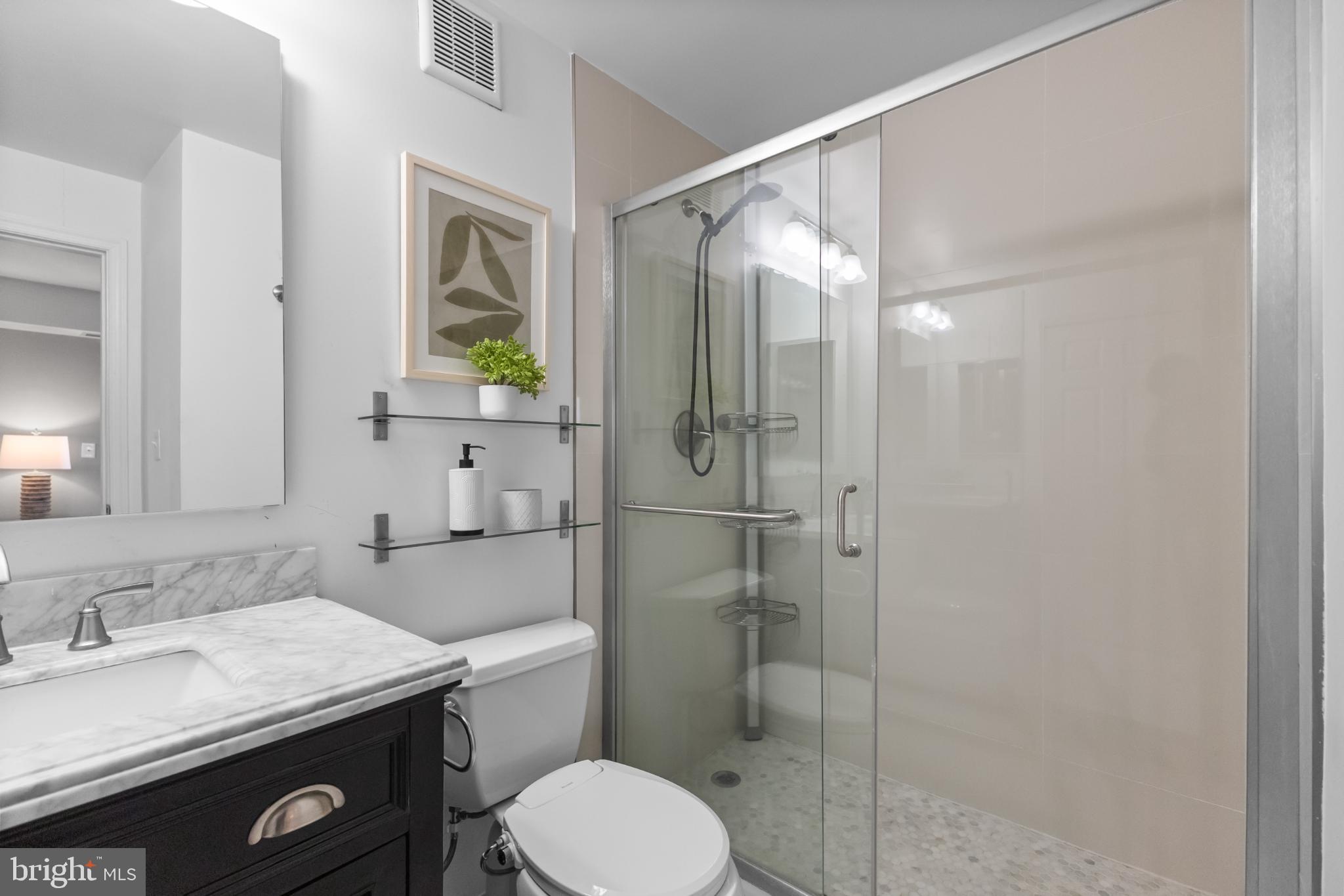 700 7th Street Southwest, Unit 813 Washington, DC 20024 - Photo 13 of 26 a bathroom with a granite countertop toilet sink and shower