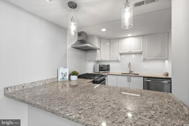 a kitchen with stainless steel appliances granite countertop a sink a stove and a refrigerator