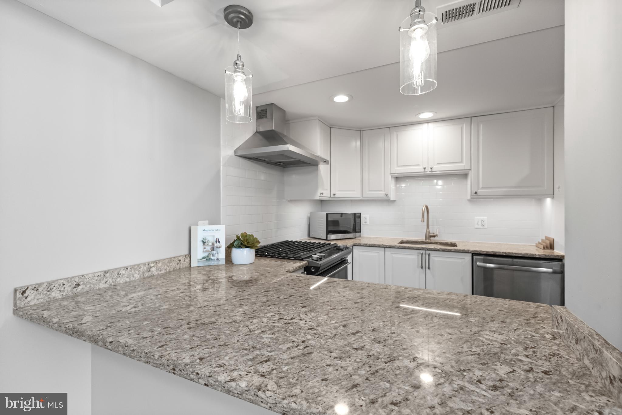 700 7th Street Southwest, Unit 813 Washington, DC 20024 - Photo 25 of 26 a kitchen with stainless steel appliances granite countertop a sink a stove and a refrigerator