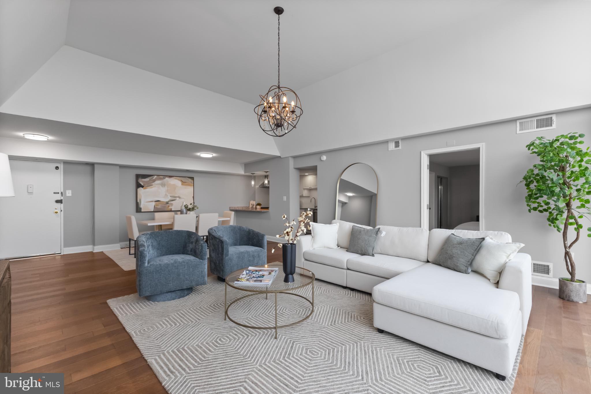 700 7th Street Southwest, Unit 813 Washington, DC 20024 - Photo 5 of 26 a living room with furniture a chandelier and a table