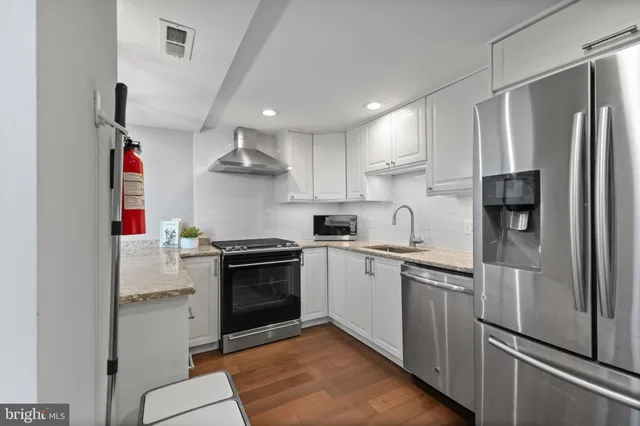 a kitchen with stainless steel appliances granite countertop a sink stove and refrigerator