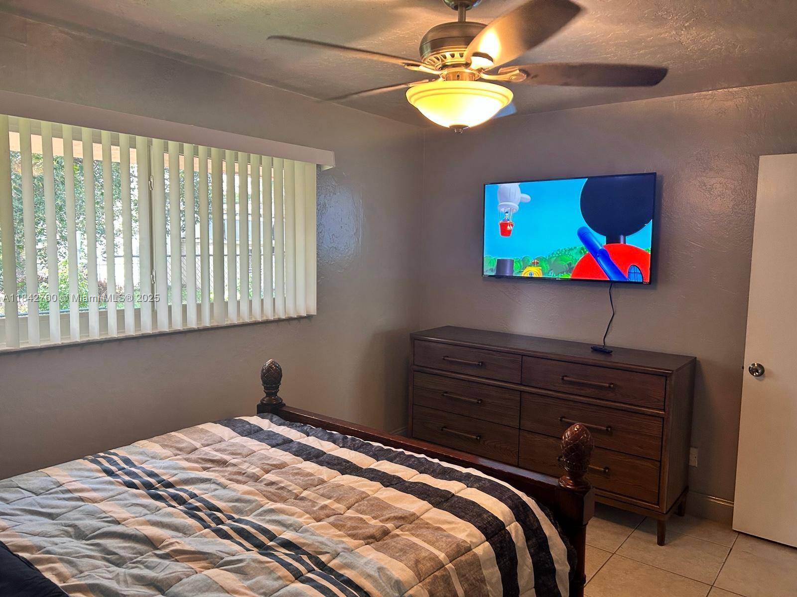 5929 Fillmore Street, Unit A Hollywood, FL 33021 - Photo 12 of 24 a bedroom with a bed and a chandelier