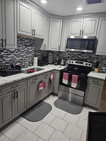 a kitchen with stainless steel appliances granite countertop a sink and a stove