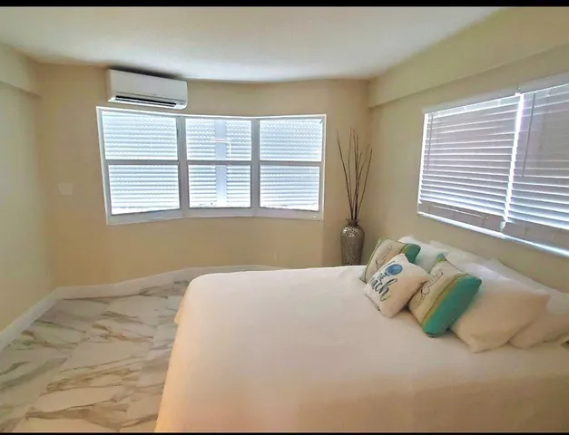 a bed sitting in a bedroom next to a window