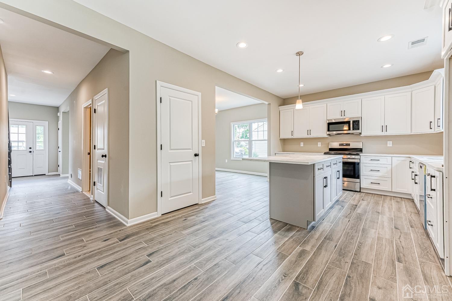 19 Crescent Road Edison, NJ 08817 - Photo 12 of 40 a kitchen with stainless steel appliances granite countertop a refrigerator a stove oven a sink dishwasher and white cabinets with wooden floor