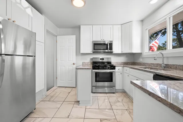 a kitchen with stainless steel appliances a refrigerator sink and microwave