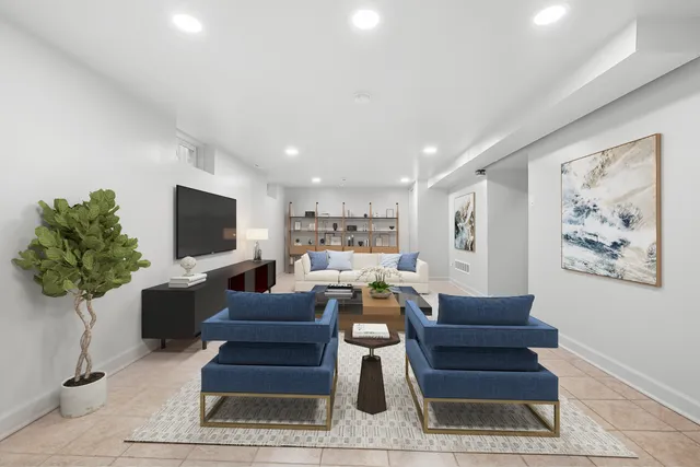 a living room with furniture a flat screen tv and a potted plant