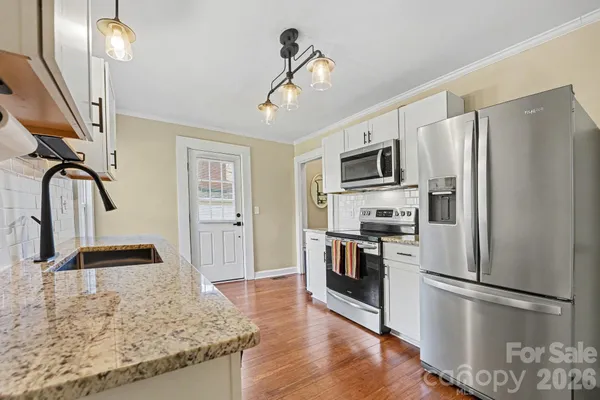a kitchen with granite countertop a refrigerator and a sink