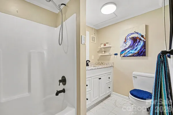a bathroom with a granite countertop sink a toilet and a shower