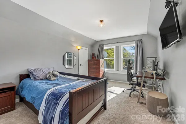 a bedroom with a bed a couch and dresser