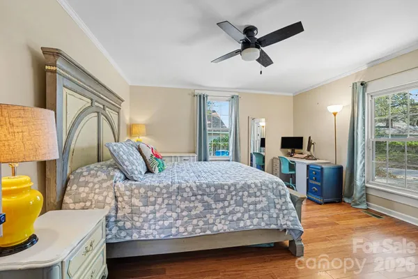 a bedroom with a bed and dresser with wooden floor