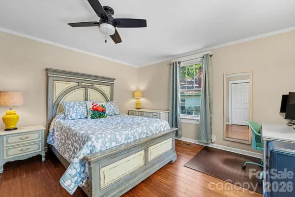 a bedroom with a bed and a flat tv screen on the dresser