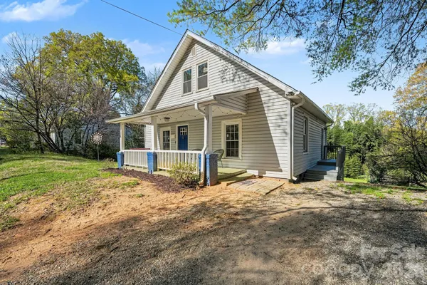 a view of house with a tree in the yard