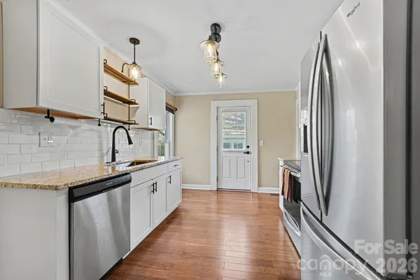 a kitchen with granite countertop a refrigerator and a sink