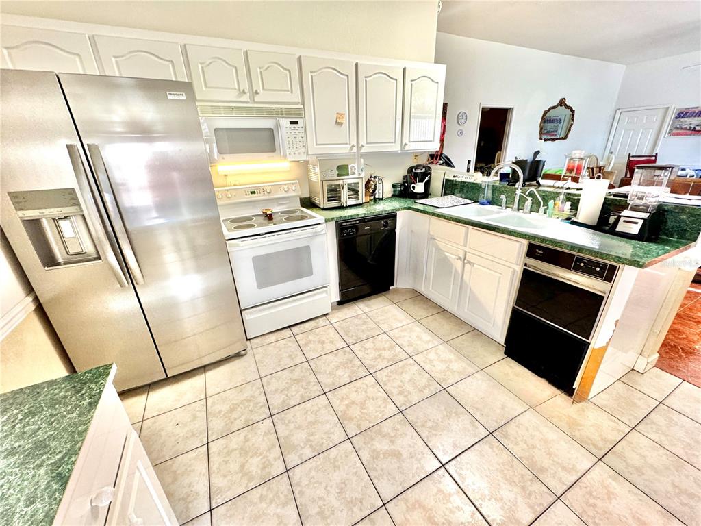 2605 Bayview Street Sebring, FL 33870 - Photo 5 of 11 a kitchen with a sink a stove a microwave and refrigerator