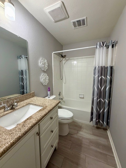 708 Ranier Lane Round Rock, TX 78665 - Photo 11 of 20 Full bath featuring shower / bathtub combination with curtain, vanity, dark wood-style floors, a textured ceiling, and a textured wall