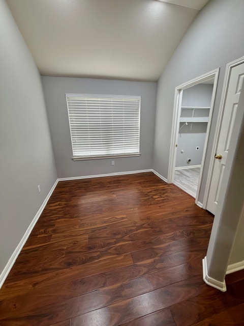 708 Ranier Lane Round Rock, TX 78665 - Photo 8 of 20 Unfurnished room featuring dark wood-style flooring and vaulted ceiling