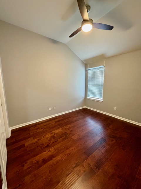 708 Ranier Lane Round Rock, TX 78665 - Photo 10 of 20 Spare room featuring vaulted ceiling and dark wood finished floors