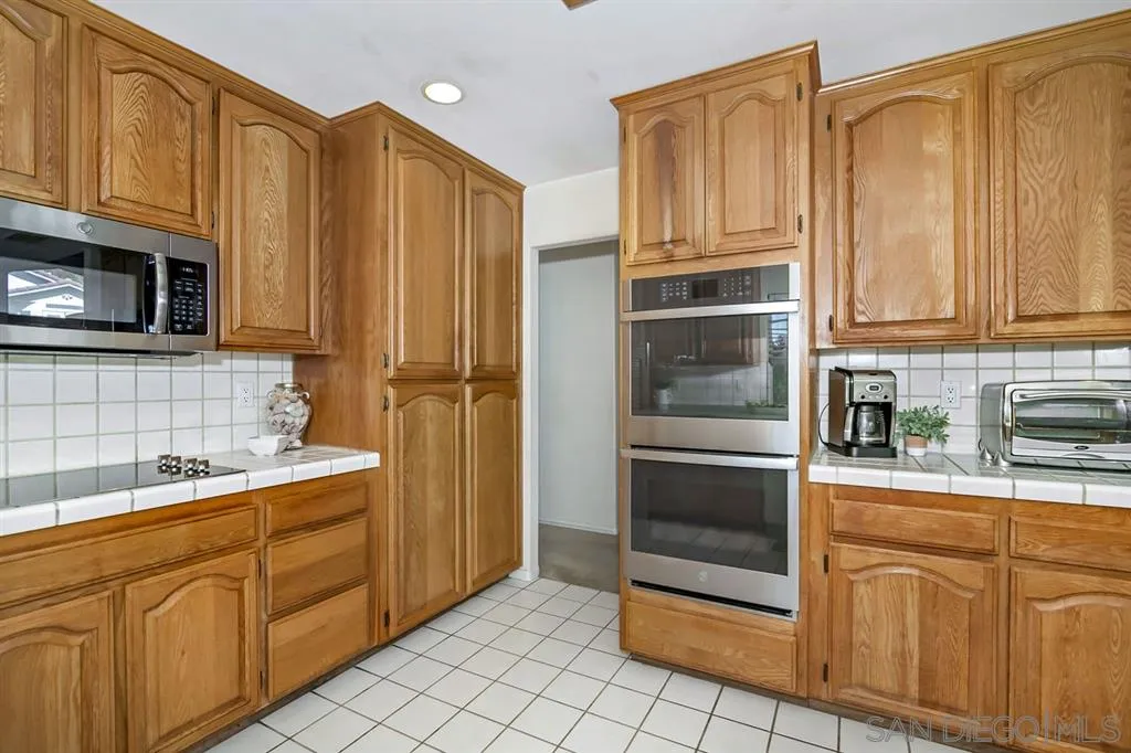1631 Dewitt Estates Road Alpine, CA 91901 - Photo 12 of 25 a kitchen with stainless steel appliances granite countertop a refrigerator and cabinets