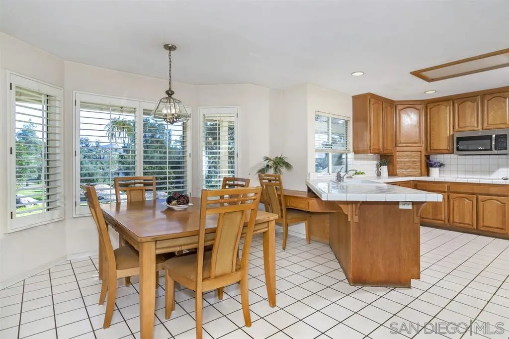 1631 Dewitt Estates Road Alpine, CA 91901 - Photo 8 of 25 a dining hall with stainless steel appliances kitchen island granite countertop a table chairs and a view of living room