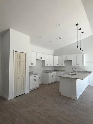 a large kitchen with cabinets and wooden floor