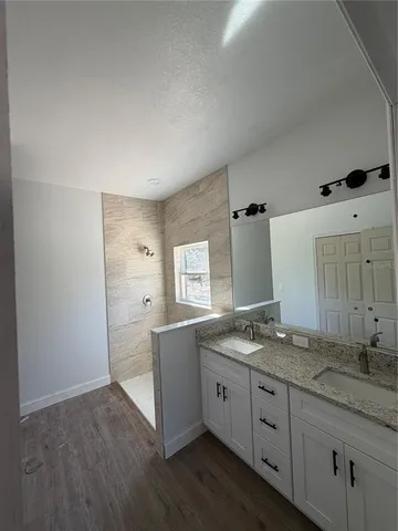a spacious bathroom with a granite countertop sink and mirror