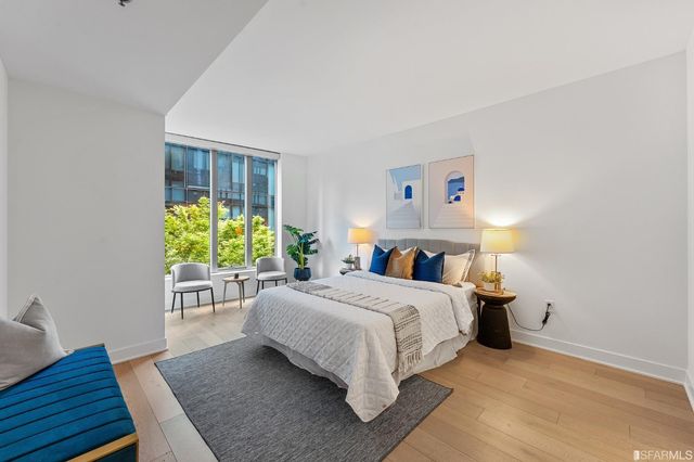 a spacious bedroom with a bed and a lamp