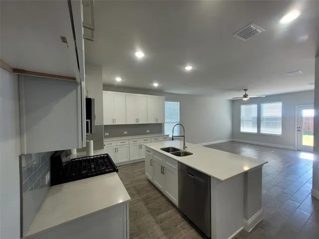 a kitchen with a stove sink and cabinets